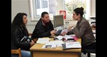 Eine Caritas-Mitarbeiterin hilft einem bulgarischen Ehepaar mit dem Schriftverkehr.