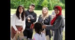 Drei junge Frauen und ein junger Mann stehen im Freien und schauen in die Kamera.