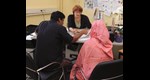Ein Mann und eine Frau lassen sich von einer Caritas-Mitarbeiterin beraten
