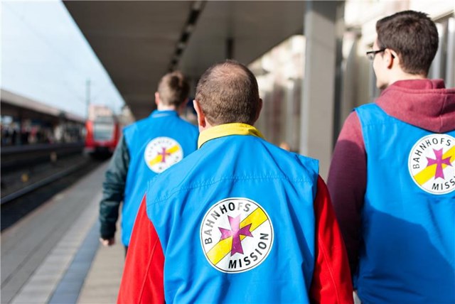Mitarbeiter der Bahnhofsmission laufen über den Bahnsteig.